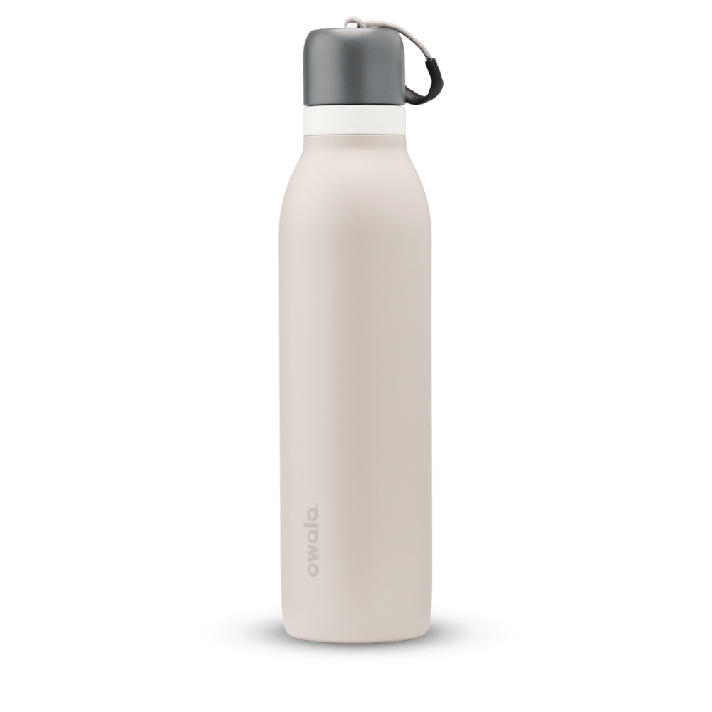 FreeSip Twist 24oz in Rock On, soft cream-beige insulated water bottle with charcoal gray twist cap, white twist cap accent band, and tan carry string with dark gray grip